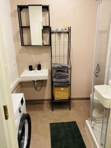 a bathroom with a sink and a shelf with towels at 1-bedroom loft in Siena Tirgus in Rīga