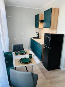 a small kitchen with a table and a refrigerator at 1-bedroom loft in Siena Tirgus in Rīga