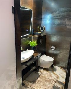 a bathroom with a white toilet and a sink at Apartament ARKANA PREMIUM in Świętochłowice