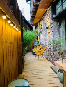 een patio met 2 stoelen en een bakstenen muur bij La Maison Rouge Au coeur de la ville. in Riquewihr