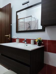 a bathroom with a sink and a mirror at Vico Stazione Apartment in Uta