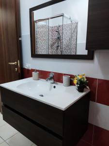 a bathroom with a sink and a mirror at Vico Stazione Apartment in Uta