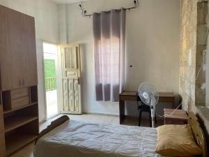 - une chambre avec un lit, un ventilateur et une fenêtre dans l'établissement Bayt Ateeq (Ateeq's house), à Bethléem