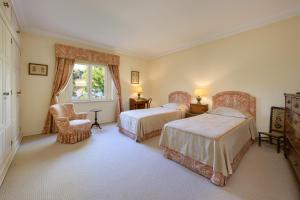 - une chambre avec deux lits, une chaise et une fenêtre dans l'établissement Villa at Quinta do Perú Golf and Country Club, à Quinta do Conde