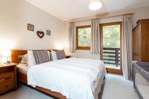 a bedroom with a white bed and a window at Chaty Daniela in Liptovský Ján