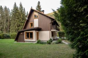 una casa en un campo con un árbol en Chaty Daniela, en Liptovský Ján