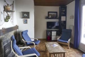 a living room with blue chairs and a fireplace at L'Escapade in Rayol-Canadel-sur-Mer