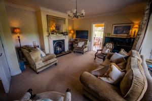 a living room with couches and chairs and a fireplace at Park Lodge Accommodation in Abbeyfeale