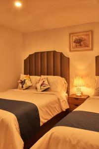 a bedroom with two beds with a large headboard at Hotel Dordéan Casona Boutique in Chachapoyas