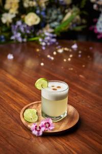 ein Glas Getränk auf einem Holztisch mit Blumen in der Unterkunft Hotel Dordéan Casona Boutique in Chachapoyas