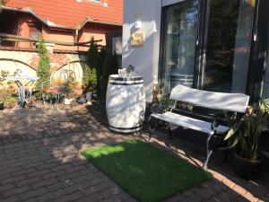 a patio with a bench and a green lawn at Greatforest Rosehill 2 Apartman in Debrecen