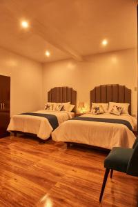 two beds in a room with wooden floors at Hotel Dordéan Casona Boutique in Chachapoyas