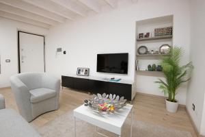 sala de estar blanca con sofá y TV en larius apartment, en Como