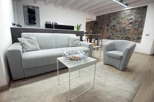 uma sala de estar com um sofá, uma cadeira e uma mesa em larius apartment em Como