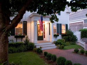 a white house with an american flag on the front porch at Ashley Inn in Edgartown