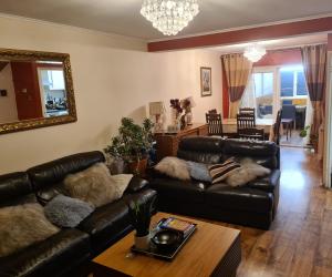 Specious Room in Northolt في Northolt: غرفة معيشة مع كنبتين جلديتين وطاولة