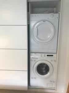 a washer and dryer in a small room at Dejlig feriebolig med havudsigt i naturskønt område in Munkebo