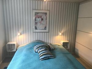 a bedroom with a blue bed with two pillows at Dejlig feriebolig med havudsigt i naturskønt område in Munkebo