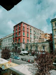 ein großes rotes Gebäude vor einem Gebäude in der Unterkunft 90's House in Neapel