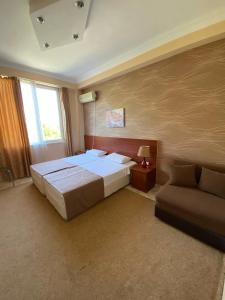 1 dormitorio con 1 cama grande y 1 sofá en Hotel Condori, en Kobuleti