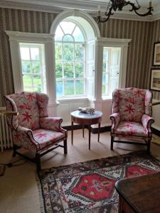 two chairs and a table in a room with a window at Summergrove House in Mountmellick
