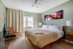 a bedroom with a large bed and a table and a chair at Oceanfront Beach House, Satellite Beach in Satellite Beach