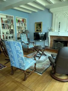 un soggiorno con due sedie e un camino di Le Pré aux Moines a Fontcouverte