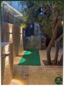 a green lawn in front of a house with a tree at AlSalti Farm - مزرعة السلطي in Ajloun