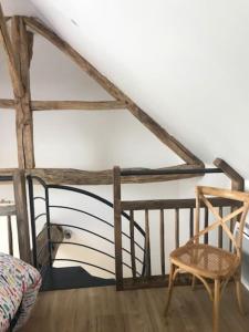 una silla y una cama en una habitación en Logement agréable à la campagne, en Saint-Symphorien