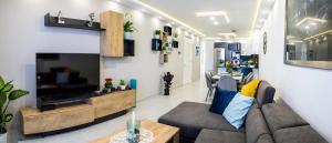 a living room with a couch and a tv at 2 bedroom luxury design apartment in Żabbar