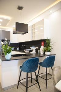 a kitchen with two blue chairs and a counter at 2 bedroom luxury design apartment in Żabbar