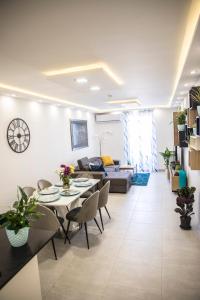 een woonkamer met een tafel en stoelen en een bank bij 2 bedroom luxury design apartment in Żabbar