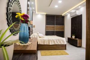 a bedroom with a bed and a vase of flowers at 2 bedroom luxury design apartment in Żabbar