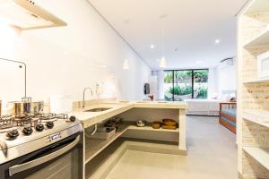 a kitchen with a sink and a stove top oven at Anoa Maresias Studios in Maresias