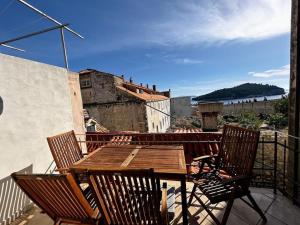 a wooden table and chairs on a balcony at Beautifully Restored 400-year Old House with Stunning Sea Views from the Terrace in Dubrovnik