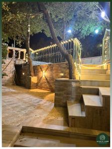 een park met een bank en een hek 's nachts bij AlSalti Farm - مزرعة السلطي in Ajloun