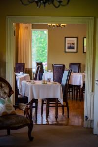 ein Esszimmer mit Tischen, Stühlen und einem Fenster in der Unterkunft Park Lodge Bed and Breakfast in Abbeyfeale