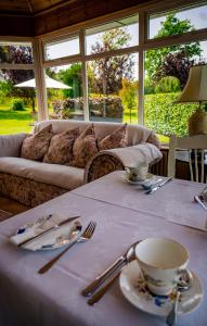 una mesa con un mantel blanco con una taza de café. en Park Lodge Bed and Breakfast en Abbeyfeale