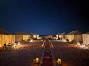 Una fila de tiendas en un desierto por la noche en Ahlam Luxury Camp, en Merzouga