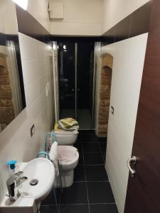 ein Badezimmer mit 2 WCs und einem Waschbecken in der Unterkunft La taverna sotto la torre in Massa Marittima