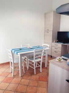kuchnia z białym stołem i białymi krzesłami w obiekcie Alle Terme w mieście Misterbianco