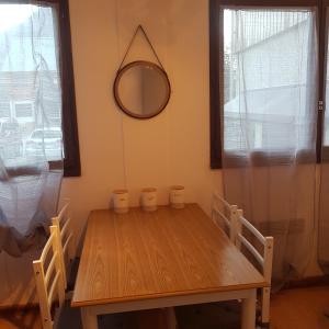 een eettafel met 2 stoelen en een spiegel bij Superbe studio dans la vallée de l'Eau d'Olle. in Allemont
