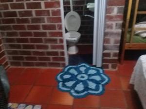 a bathroom with a toilet on a tile floor at restaurante pousada gaucha bigode in Passo de Torres