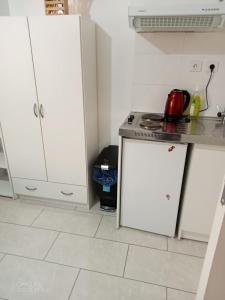 eine Küche mit weißen Schränken und einem Herd mit Backofen in der Unterkunft ZEN & LUXURY Studio Paris Montreuil in Montreuil