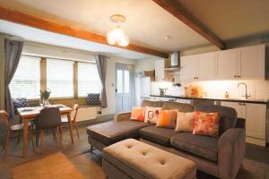 a living room with a couch and a table and a kitchen at Weavers Retreat by Weavers of Haworth in Haworth