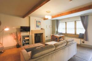 ein Wohnzimmer mit einem Sofa und einem Kamin in der Unterkunft Weavers Retreat by Weavers of Haworth in Haworth