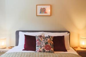 a bedroom with a bed with pillows and two lamps at Weavers Retreat by Weavers of Haworth in Haworth