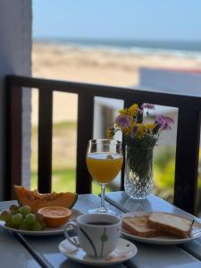 a table with a glass of wine and a vase of flowers at El Diablo Chic Colonial in Punta Del Diablo +34 photos