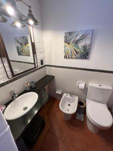 a bathroom with a toilet and a sink and a mirror at El Diablo Chic Colonial in Punta Del Diablo