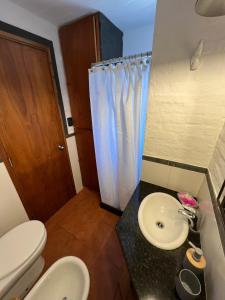 a bathroom with two toilets and a sink and a shower at El Diablo Chic Colonial in Punta Del Diablo